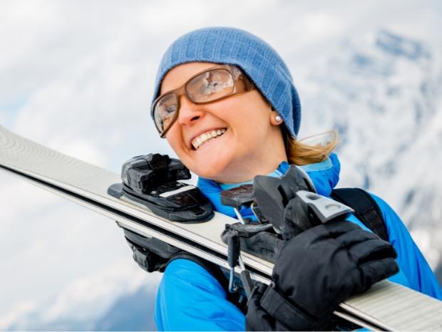 Uśmiechnięta kobieta trzymająca narty